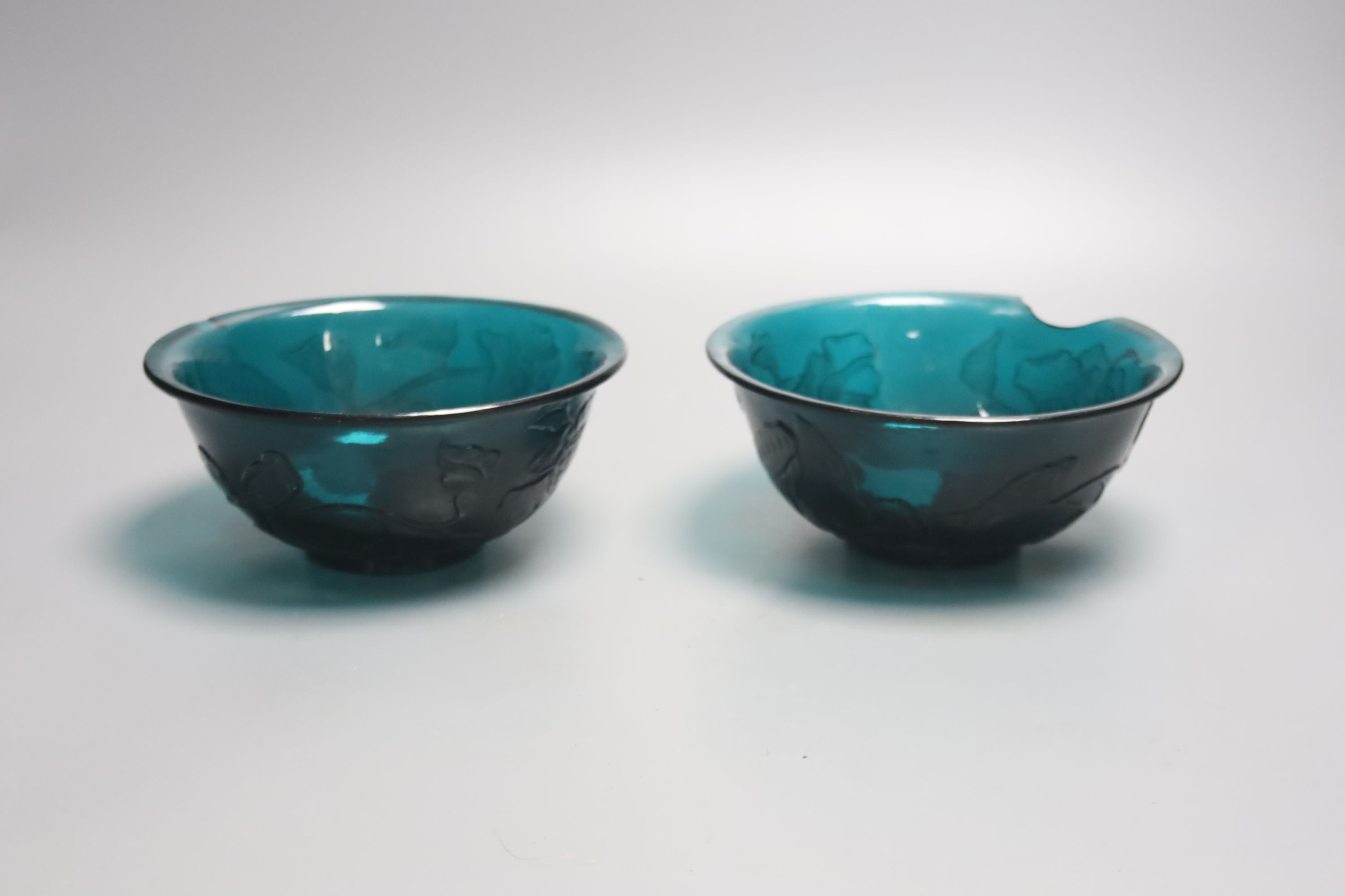 A pair of Chinese Beijing green glass bowls, Qianlong four character and of the period, diameter 16.5cm, some damage